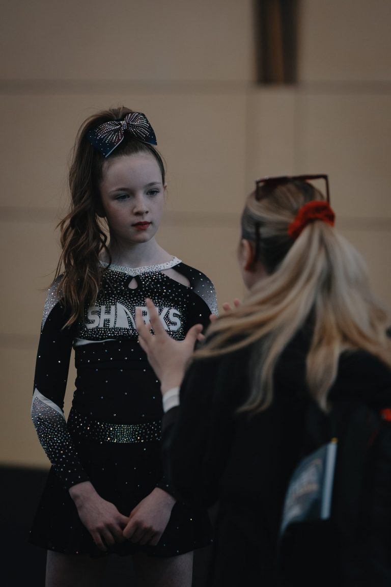 Sharks-Cheerleaderinnen konzentrieren sich vor ihrem Auftritt und bespricht letzte dinge mit einem Coach